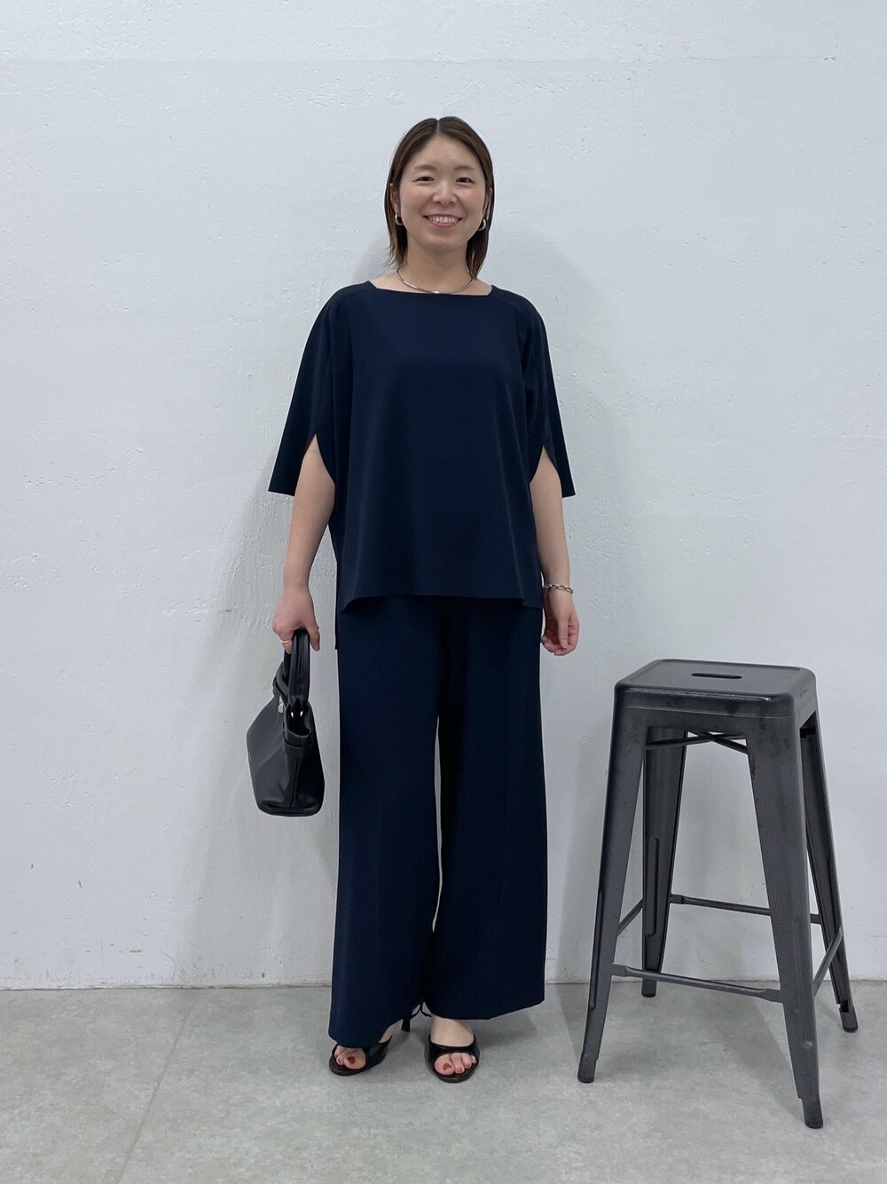 ブルー系のスラックス、ブルー系のシャツ/ブラウス、ブラック系のトートバッグを着用したレディースの春コーディネートの1枚目の写真