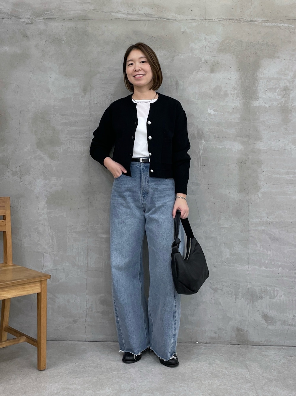 ブラック系のカーディガン/ボレロ、ブルー系のデニムパンツ、ホワイト系のTシャツ/カットソーを着用したレディースの冬コーディネートの1枚目の写真