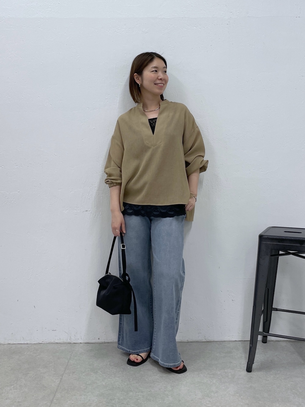 ベージュ系のシャツ/ブラウス、ブラック系のキャミソール、ブルー系のデニムパンツを着用したレディースの春コーディネートの1枚目の写真