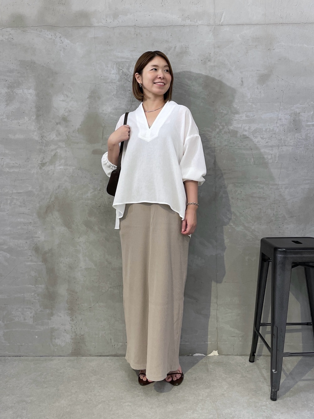 ホワイト系のシャツ/ブラウス、ベージュ系のワンピース、ブラウン系のショルダーバッグを着用したレディースの夏コーディネートの1枚目の写真