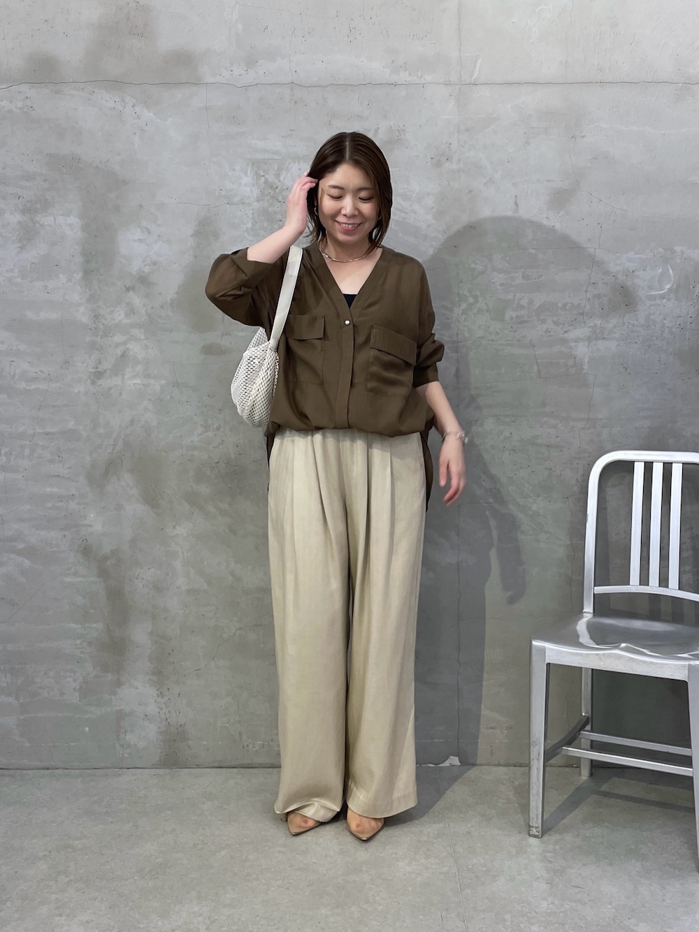グリーン系のシャツ/ブラウス、ベージュ系のその他パンツ、ホワイト系のショルダーバッグを着用したレディースの夏コーディネートの1枚目の写真