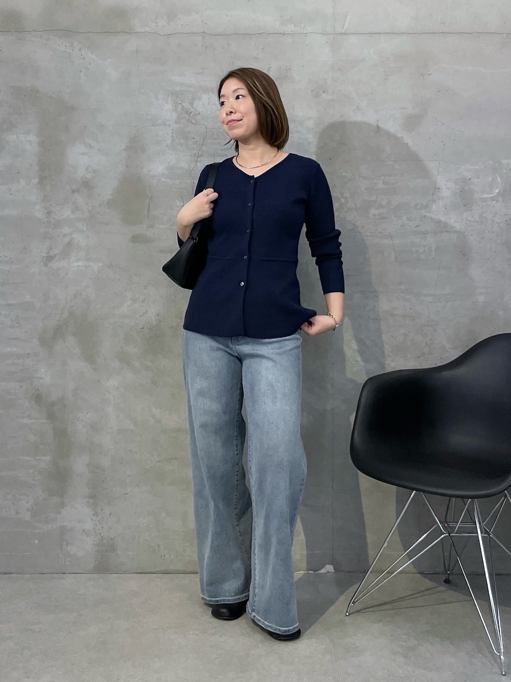 ブルー系のカーディガン/ボレロ、ブルー系のデニムパンツ、ブラック系のショルダーバッグを着用したレディースの冬コーディネートの1枚目の写真
