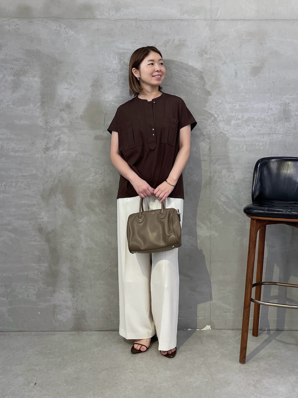 ブラウン系のTシャツ/カットソー、ホワイト系のスラックス、ブラウン系のボストンバッグを着用したレディースの夏コーディネートの1枚目の写真