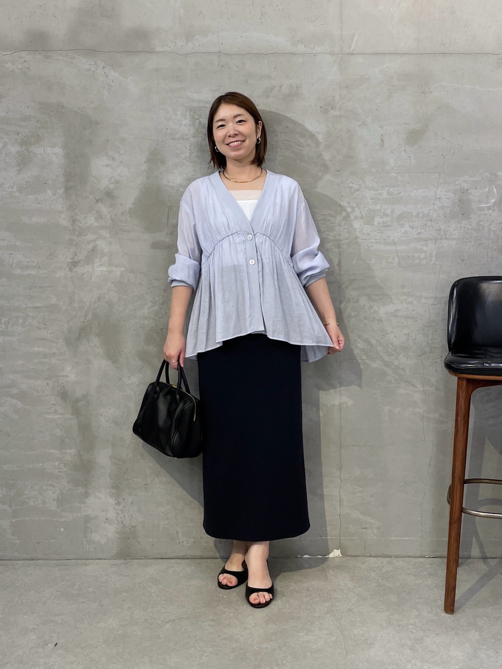 ブルー系のシャツ/ブラウス、ブラック系のスカート、ブラック系のボストンバッグを着用したレディースの夏コーディネートの1枚目の写真