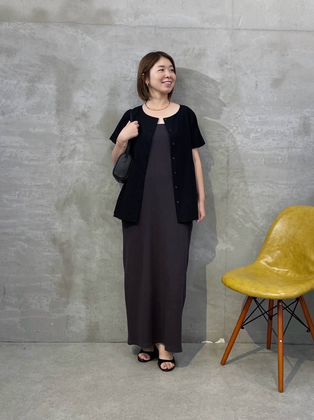 ブラック系のシャツ/ブラウス、グレー系のワンピース、ブラック系のショルダーバッグを着用したレディースの夏コーディネートの1枚目の写真