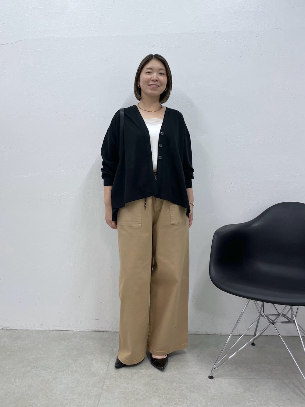 ホワイト系のタンクトップ、ベージュ系のデニムパンツ、ブラック系のカーディガン/ボレロを着用したレディースの夏コーディネートの1枚目の写真