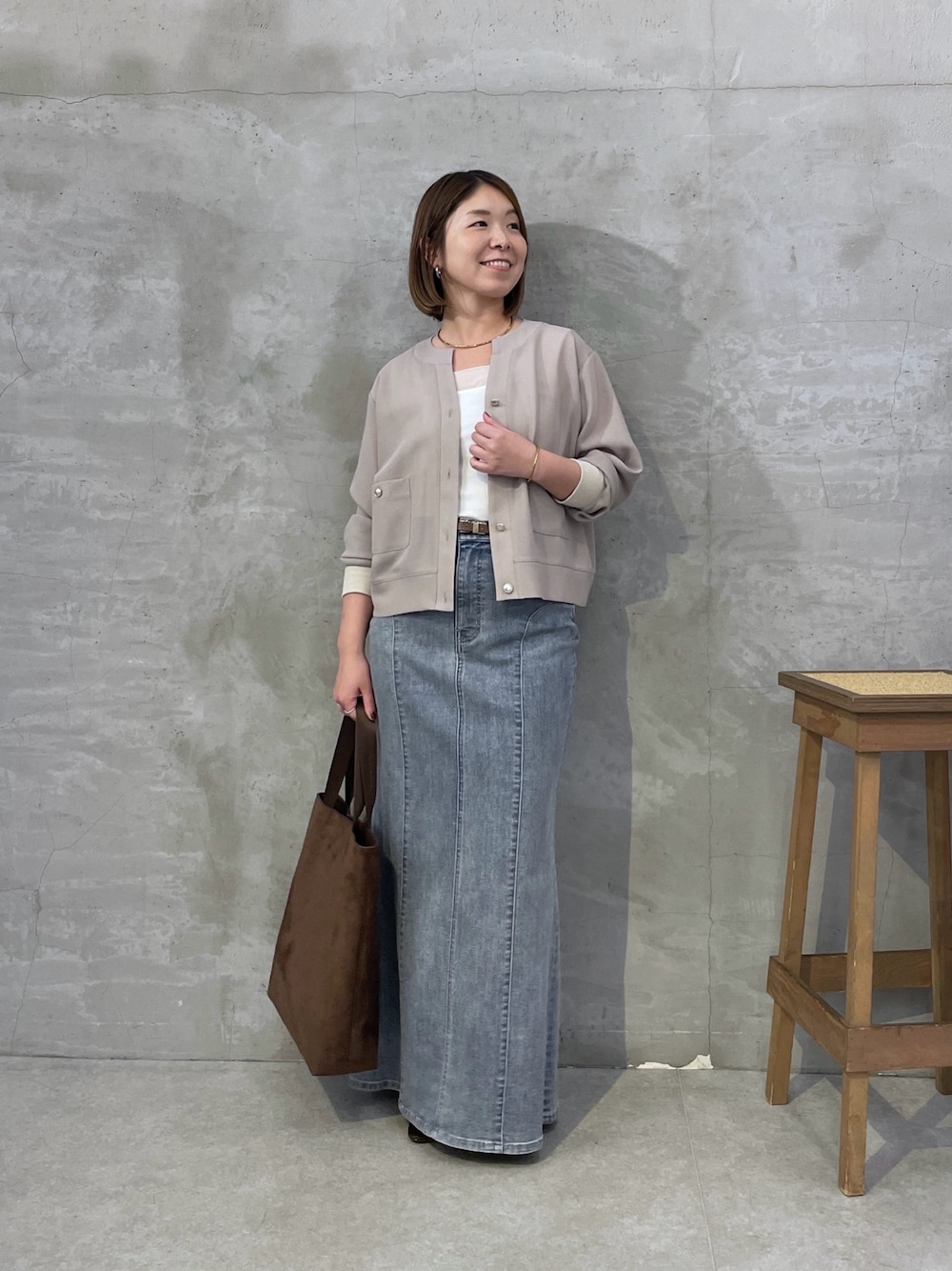 ベージュ系のカーディガン/ボレロ、ブルー系のスカート、ブラウン系のトートバッグを着用したレディースの夏コーディネートの1枚目の写真