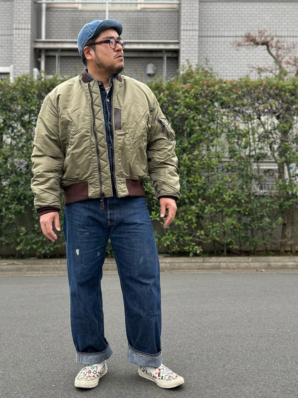 グリーン系のミリタリージャケット、ブルー系のデニムパンツ、ブルー系のデニムジャケットを着用したメンズの冬コーディネートの1枚目の写真