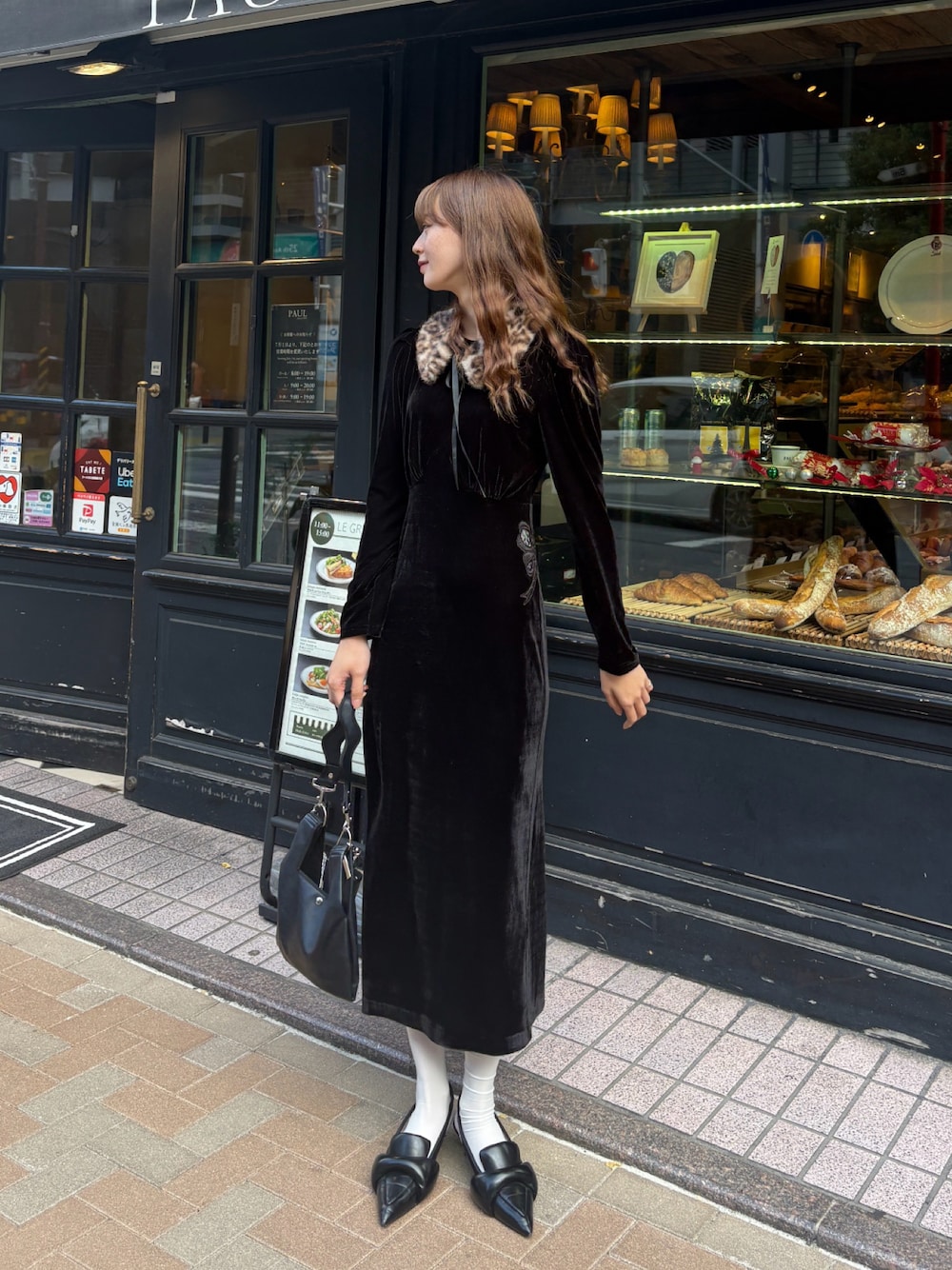 ブラック系のドレスを着用したレディースの秋コーディネートの1枚目の写真