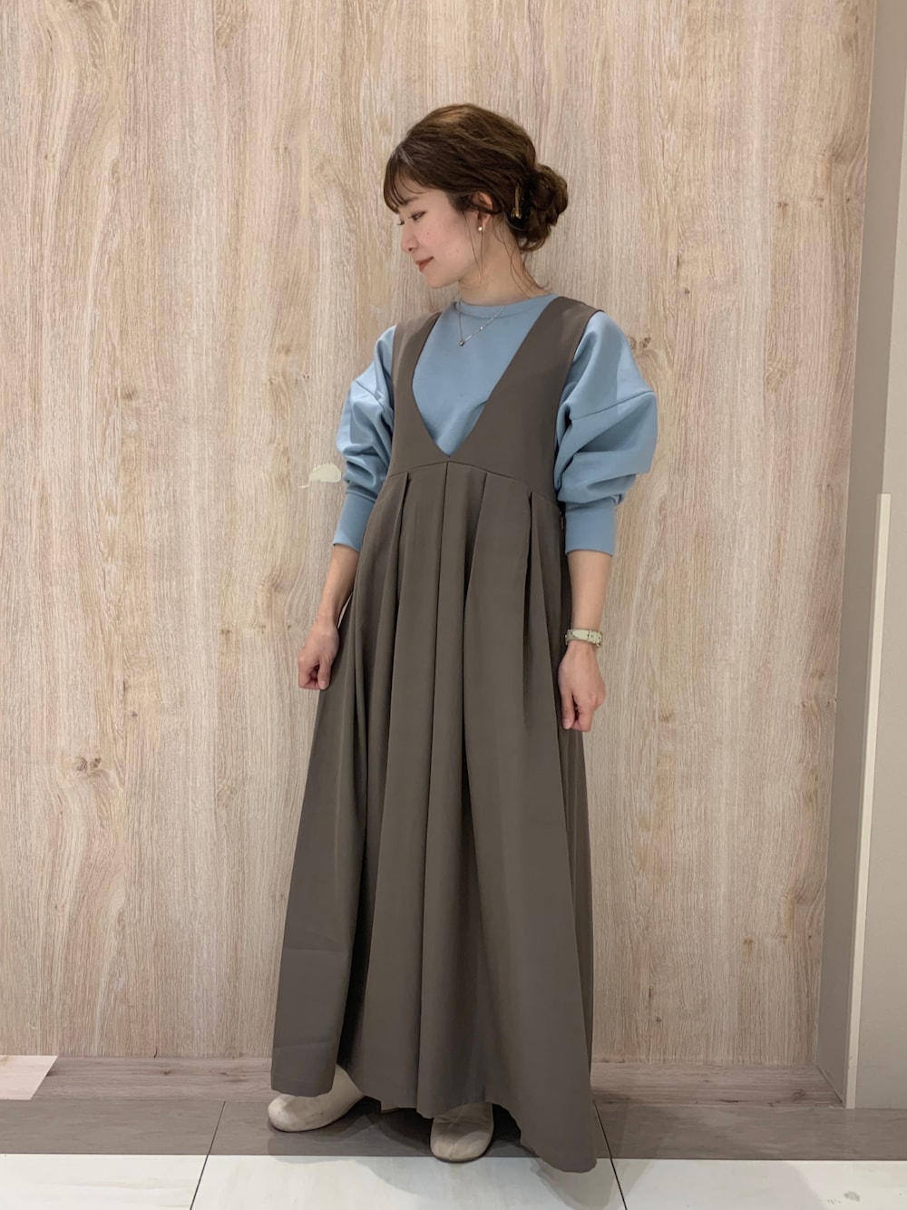 ブルー系のスウェット、ベージュ系のジャンパースカート、その他のブーツを着用したレディースの冬コーディネートの1枚目の写真