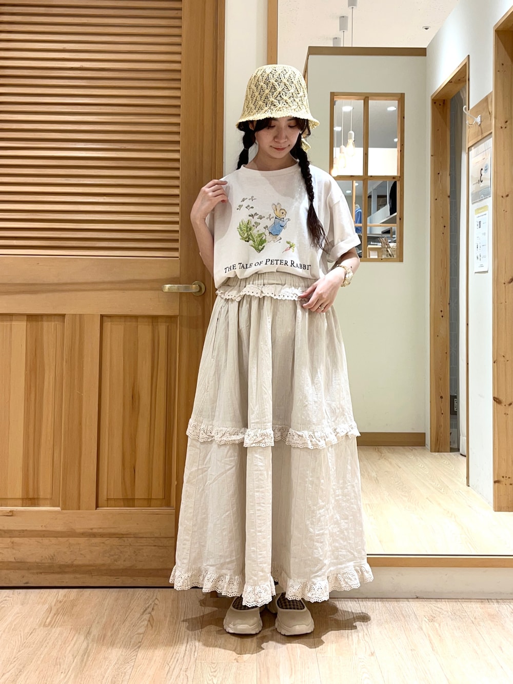 ホワイト系のTシャツ/カットソー、ベージュ系のスカート、ベージュ系のスニーカーを着用したレディースの春コーディネートの1枚目の写真