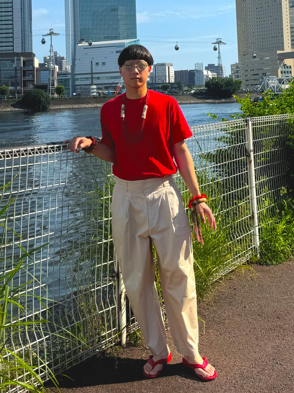 レッド系のTシャツ/カットソー、ベージュ系のその他パンツ、その他のサングラスを着用したメンズの夏コーディネートの1枚目の写真