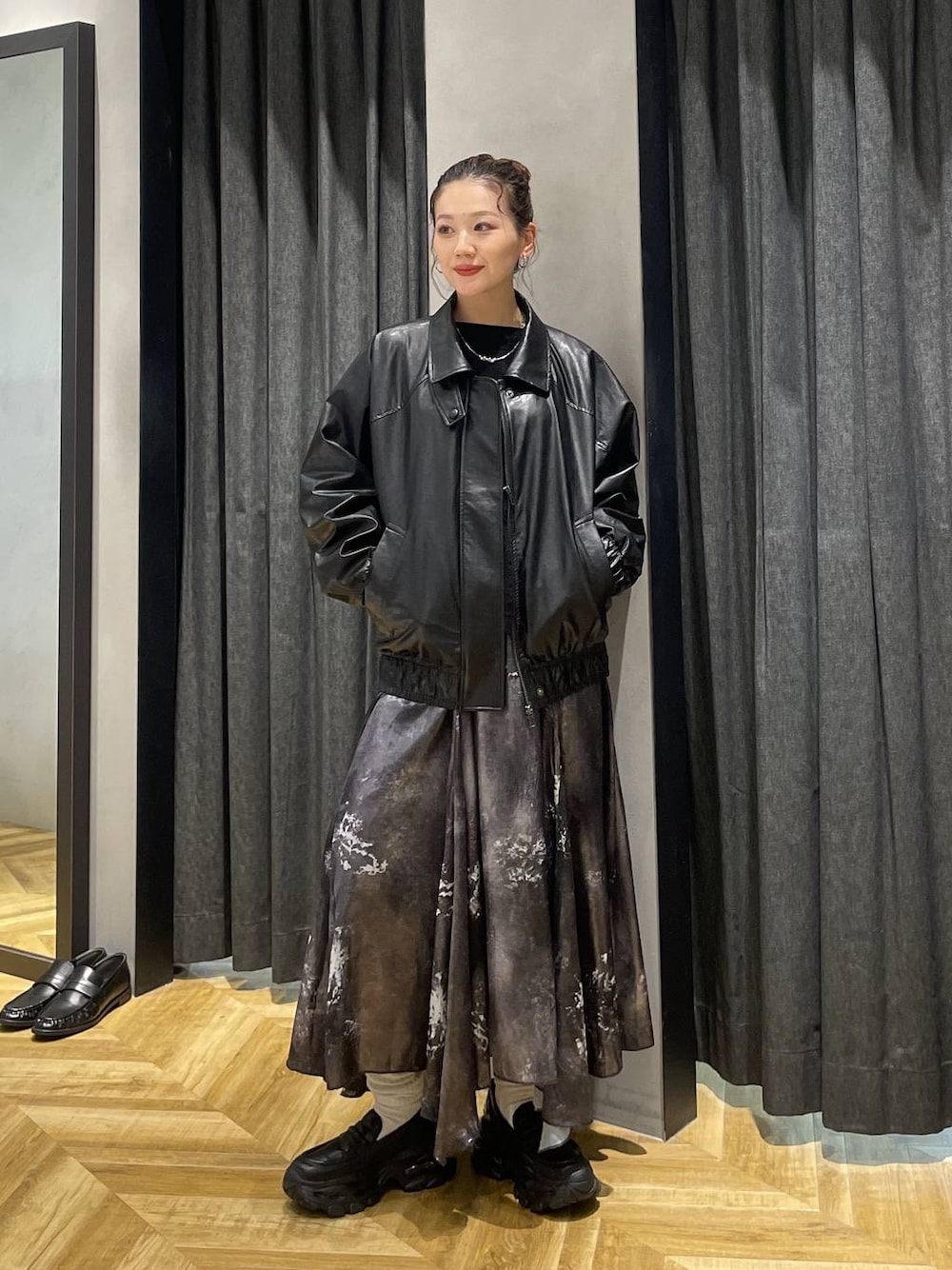 ブラック系のローファー、ブラック系のブルゾン、シルバー系のスカートを着用したレディースの冬コーディネートの1枚目の写真