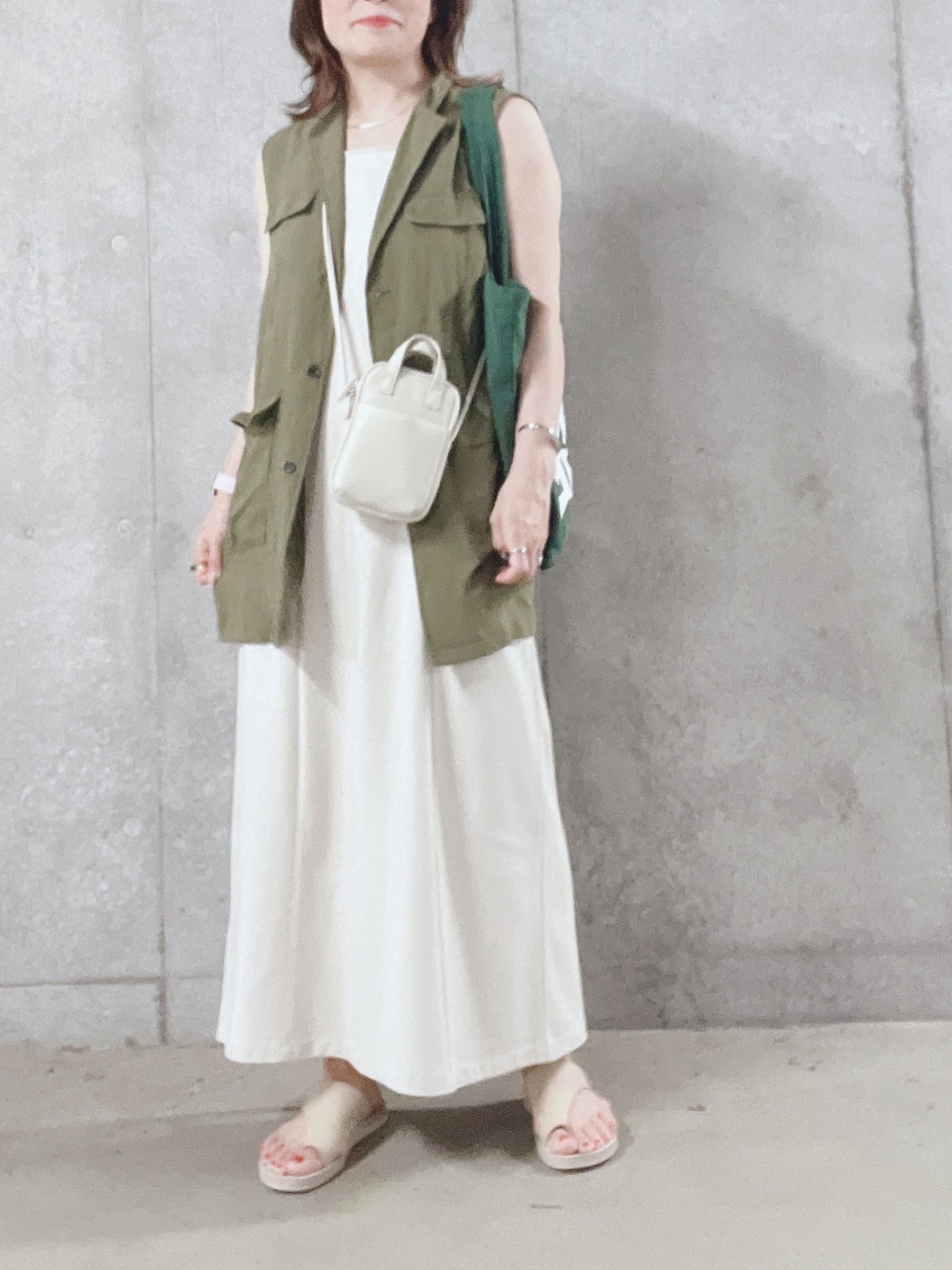 ホワイト系のショルダーバッグ、ホワイト系のワンピース、ホワイト系のサンダルを着用したレディースの夏コーディネートの1枚目の写真