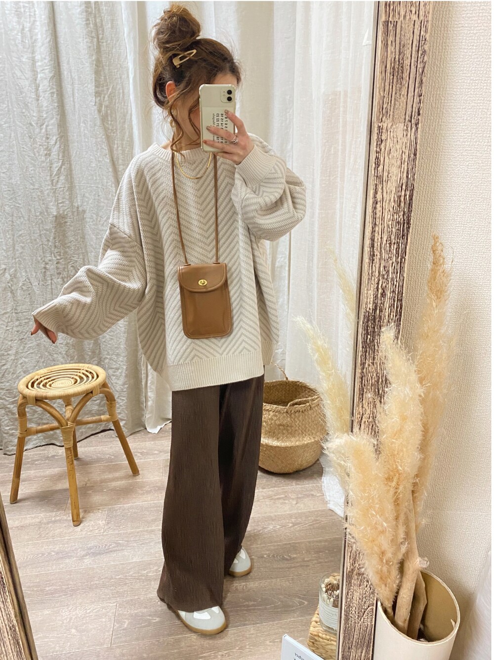 ベージュ系のニット/セーター、イエロー系のショルダーバッグ、ブラウン系のパンツを着用したレディースの冬コーディネートの1枚目の写真