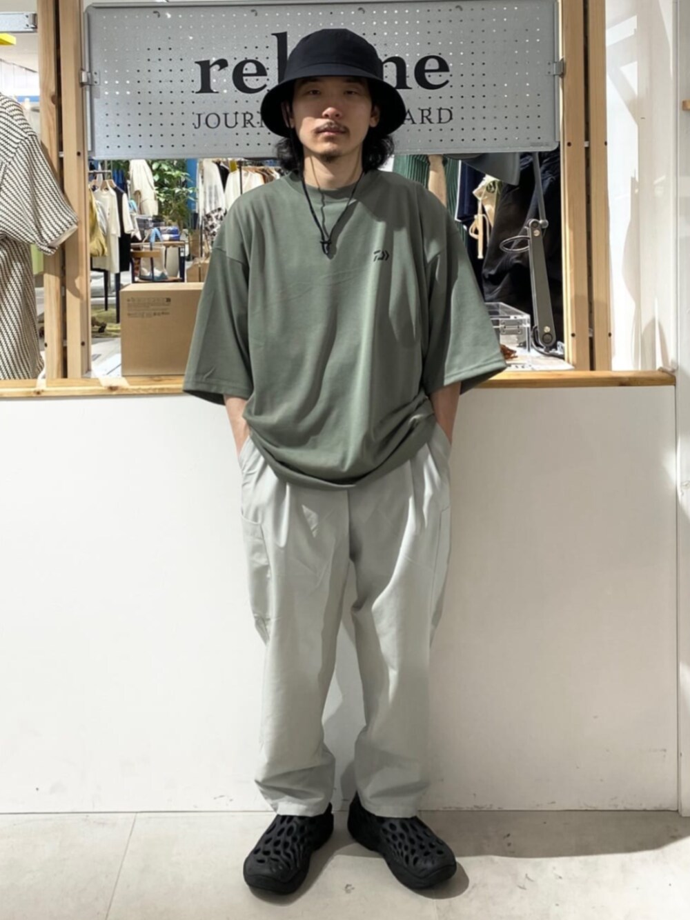 ブラック系のサンダル、グレー系のTシャツ/カットソー、グレー系のスラックスを着用したメンズの夏コーディネートの1枚目の写真