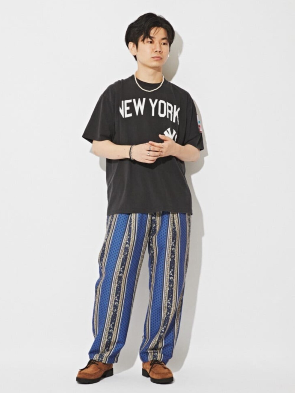 ブルー系のスラックス、ブラック系のTシャツ/カットソーを着用したメンズの夏コーディネートの1枚目の写真