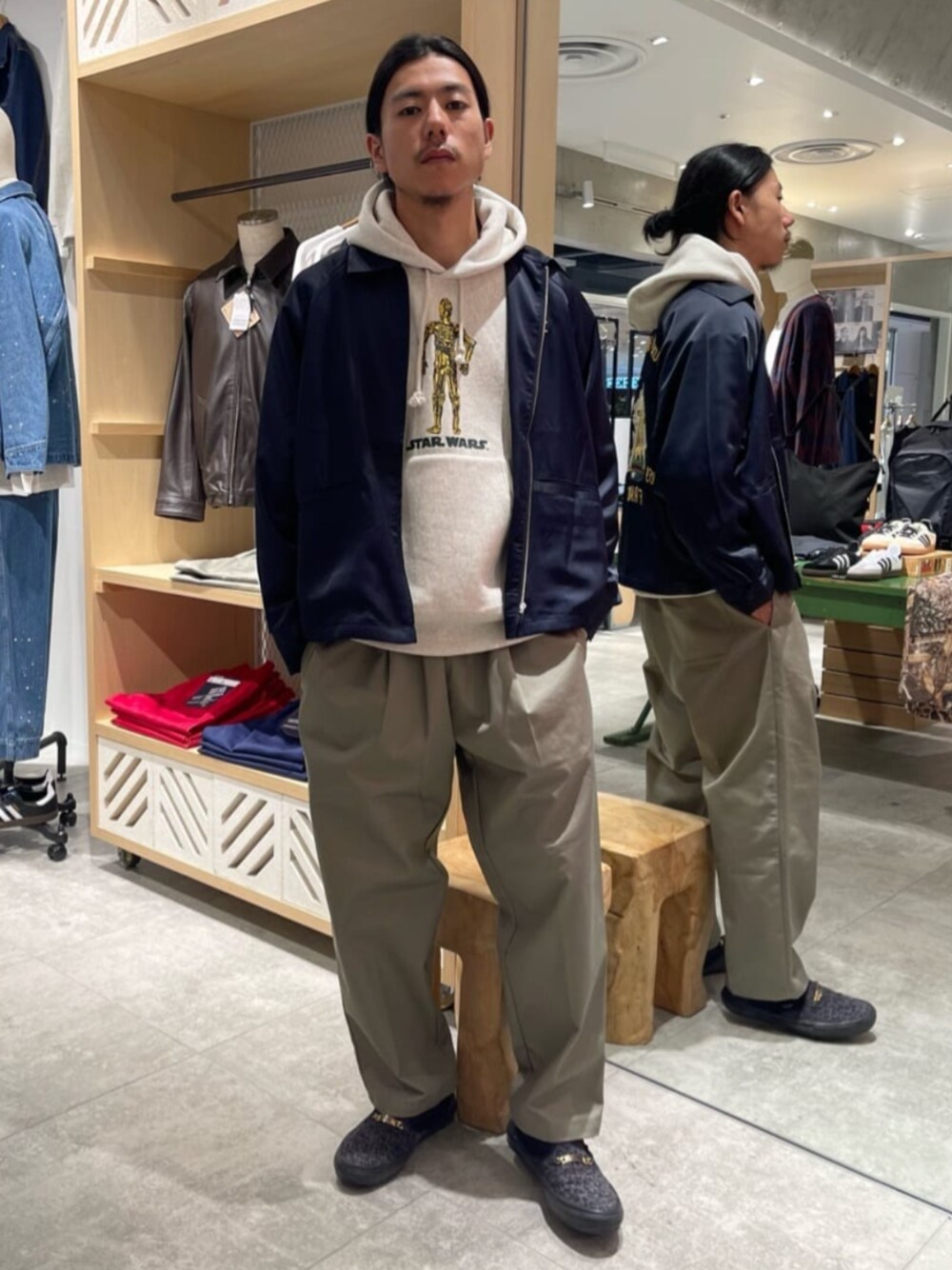 ホワイト系のパーカー、ブルー系のミリタリージャケット、グリーン系のその他パンツを着用したメンズの秋コーディネートの1枚目の写真