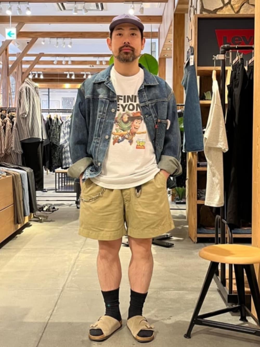 ブルー系のデニムジャケット、ホワイト系のTシャツ/カットソー、ベージュ系のサンダルを着用したメンズの夏コーディネートの1枚目の写真