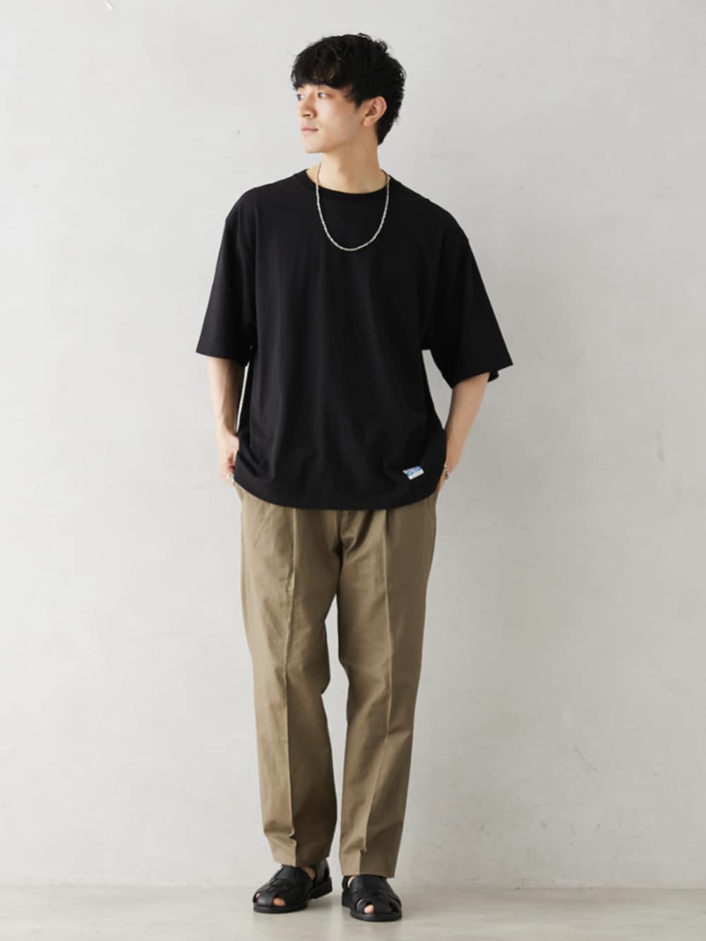 ブラック系のTシャツ/カットソーを着用したメンズの夏コーディネートの1枚目の写真