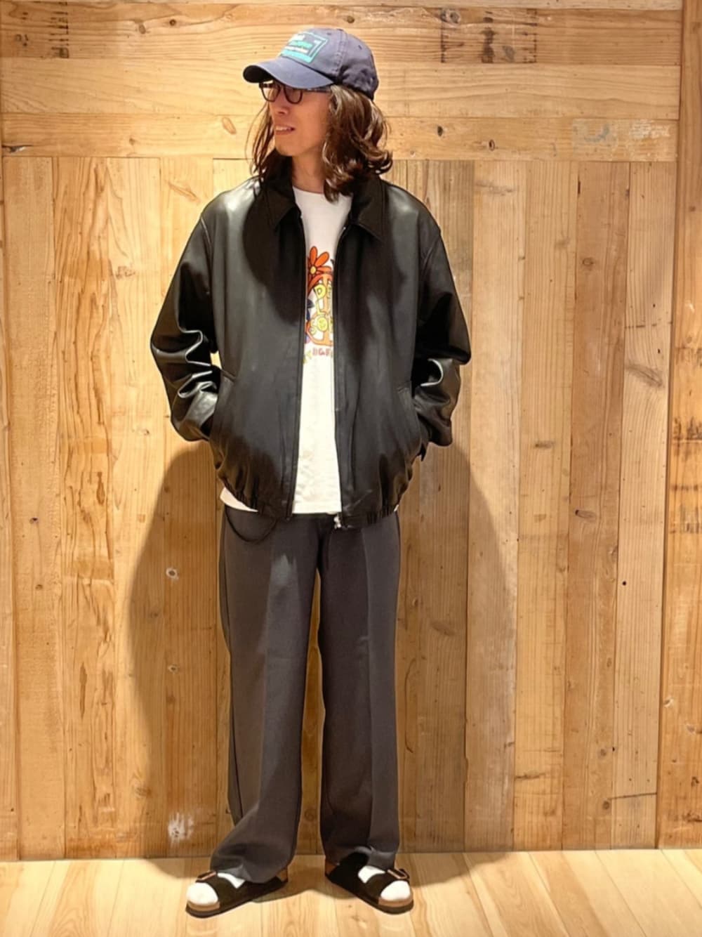 グレー系のスラックス、ブラック系のライダースジャケット、ホワイト系のTシャツ/カットソーを着用したメンズの秋コーディネートの1枚目の写真