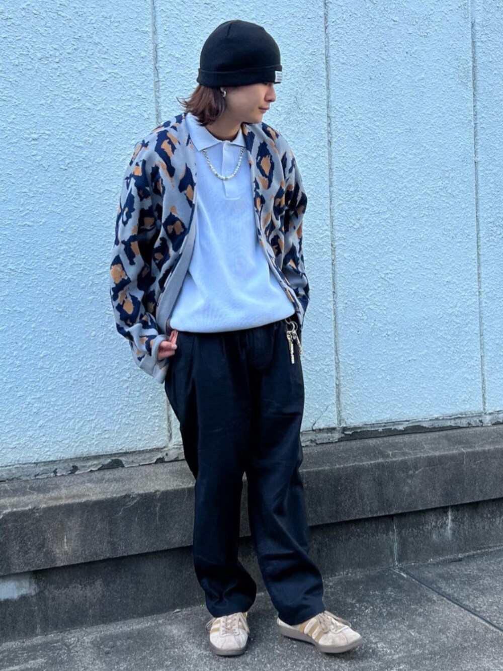 グレー系のカーディガン/ボレロ、ブルー系のニット/セーター、ブラック系のスラックスを着用したメンズの春コーディネートの1枚目の写真