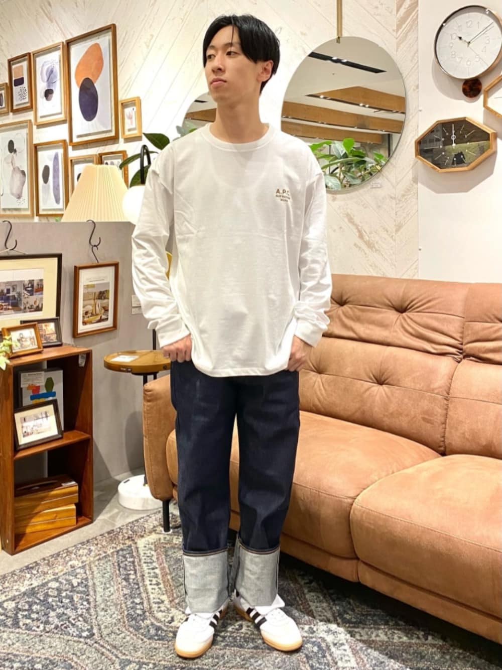 ホワイト系のTシャツ/カットソー、ホワイト系のスニーカー、ブルー系のデニムパンツを着用したメンズの秋コーディネートの1枚目の写真