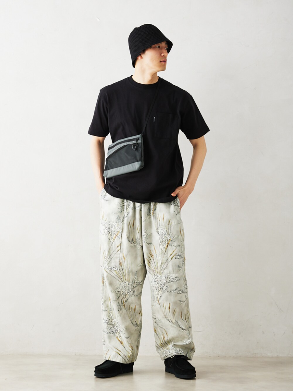 グレー系のその他パンツ、ブラック系のその他シューズ、ブラック系のTシャツ/カットソーを着用したメンズの春コーディネートの1枚目の写真