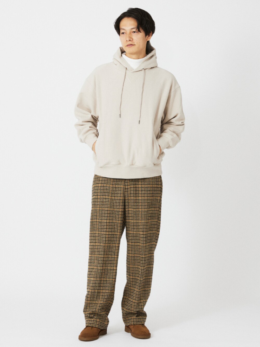 ホワイト系のTシャツ/カットソー、ベージュ系のスラックス、グレー系のパーカーを着用したメンズの冬コーディネートの1枚目の写真