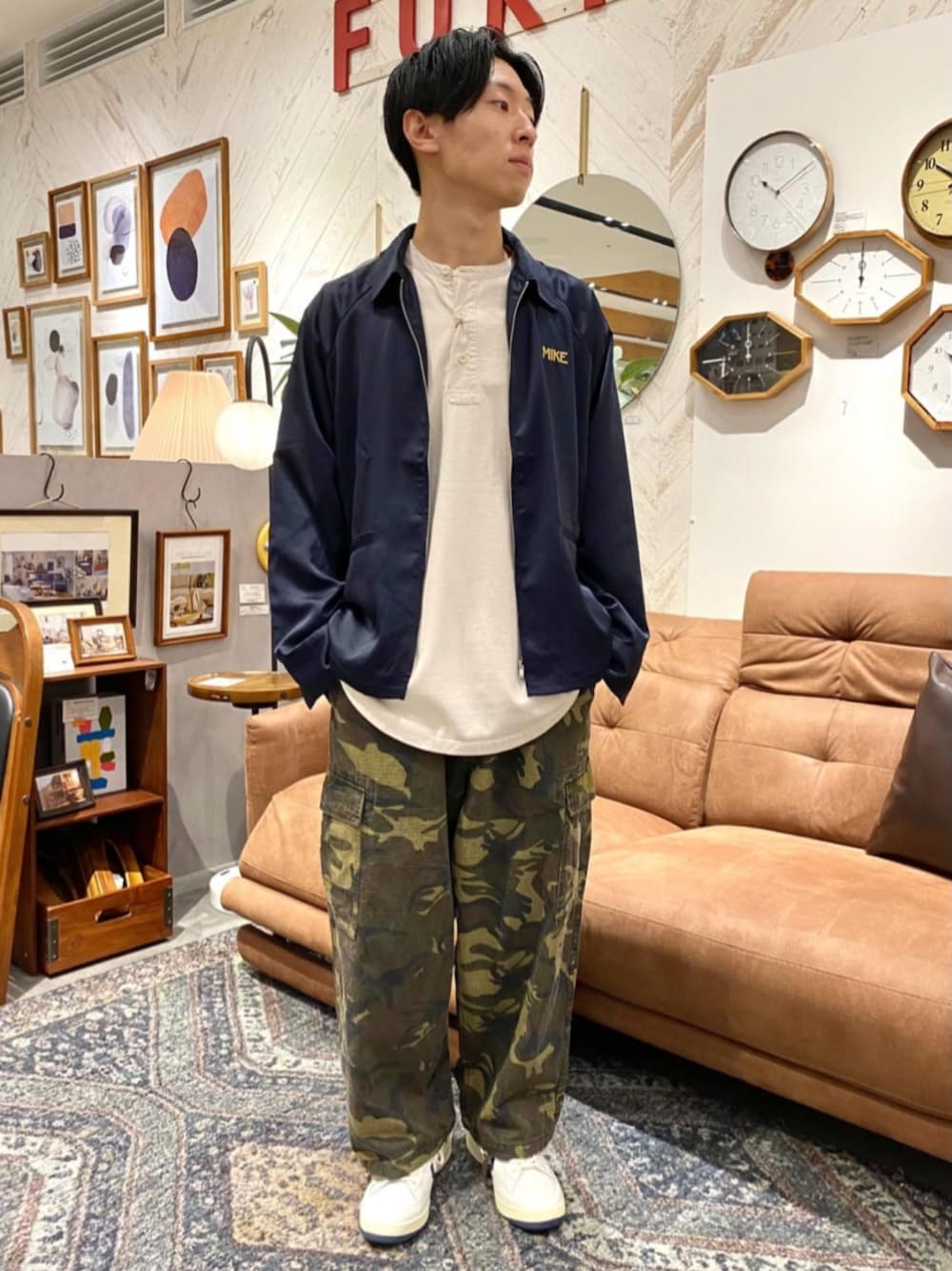 ブルー系のミリタリージャケット、ベージュ系のTシャツ/カットソー、ブルー系のスニーカーを着用したメンズの秋コーディネートの1枚目の写真