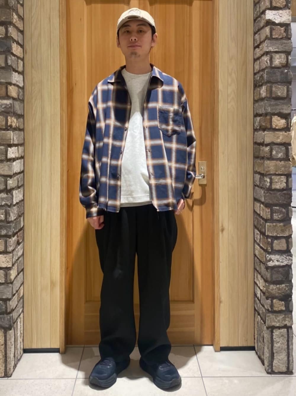 ブラック系のスラックス、ブラウン系のシャツ/ブラウス、グレー系のTシャツ/カットソーを着用したメンズの春コーディネートの1枚目の写真