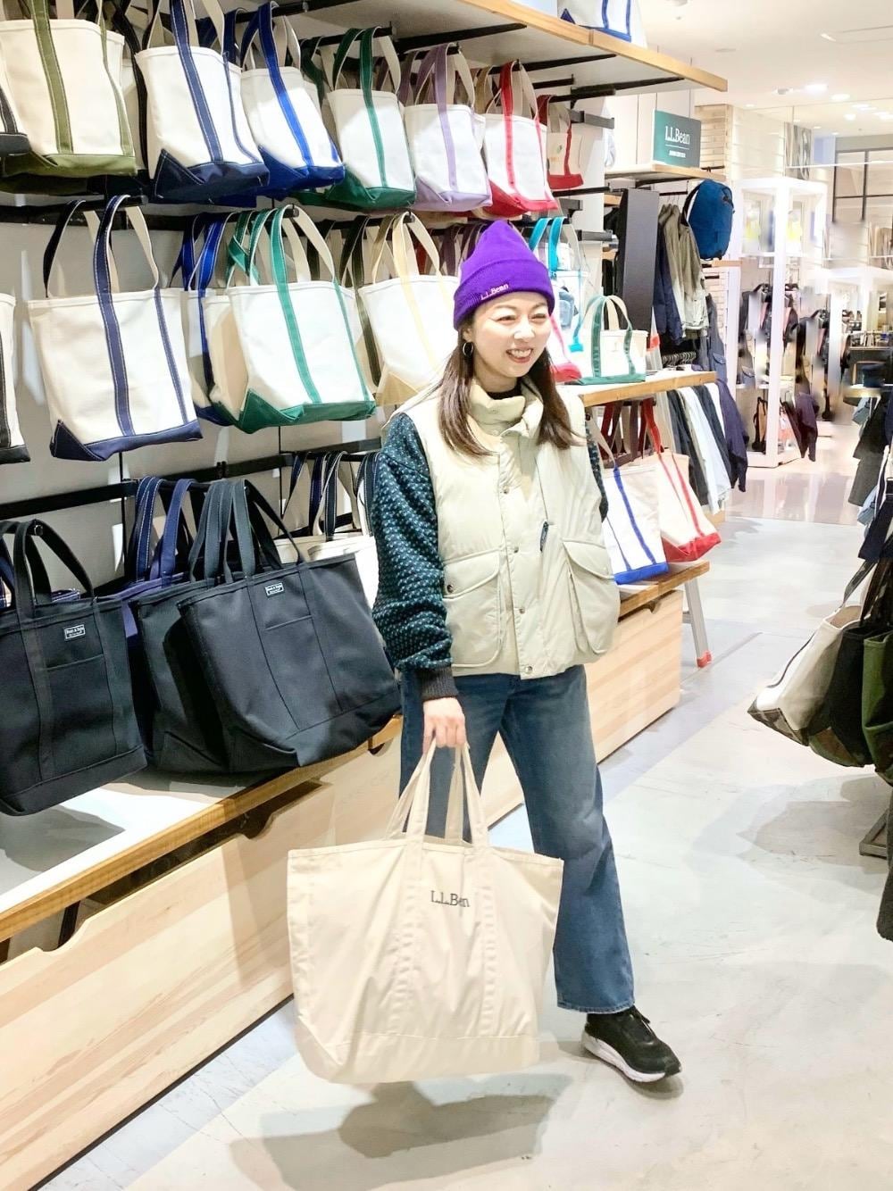 ホワイト系のトートバッグ、ブルー系のデニムパンツ、ブルー系のニット/セーターを着用したレディースの秋コーディネートの1枚目の写真