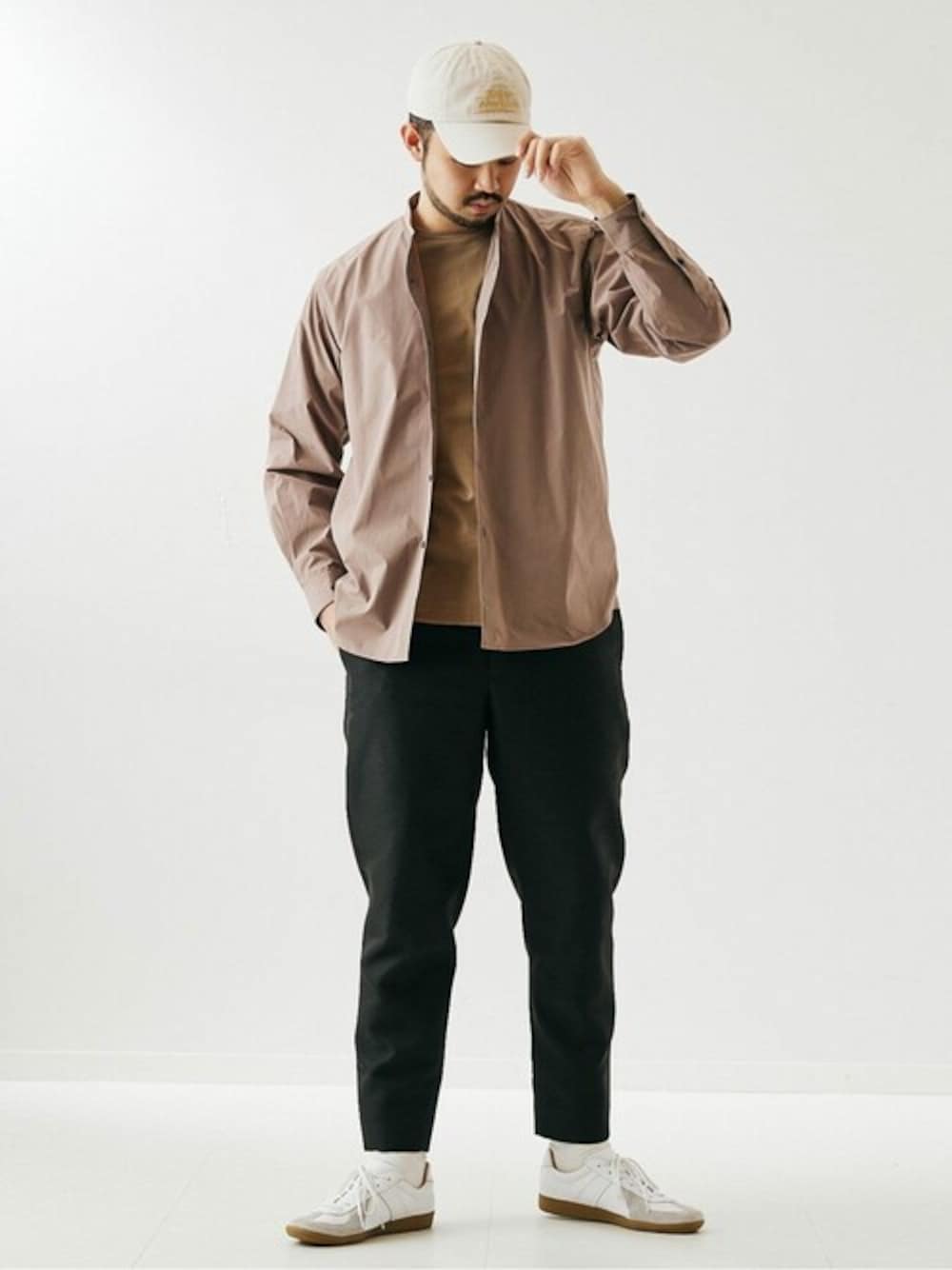 ブラウン系のシャツ/ブラウス、ブラック系のスラックス、ホワイト系のスニーカーを着用したメンズの春コーディネートの1枚目の写真