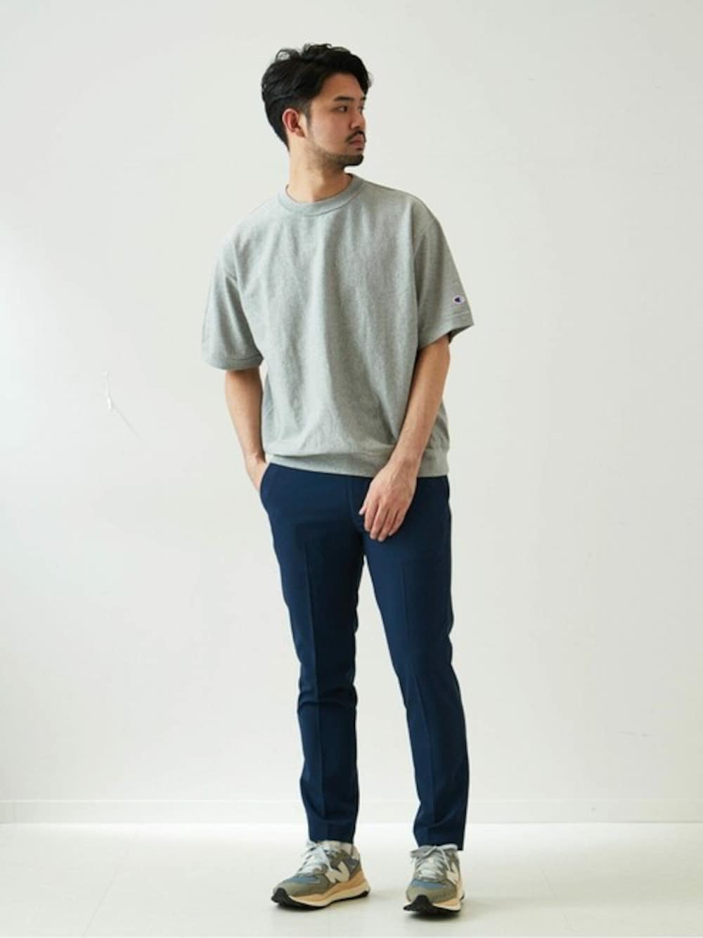 グレー系のTシャツ/カットソー、ブルー系のスラックス、グレー系のスニーカーを着用したメンズの春コーディネートの1枚目の写真