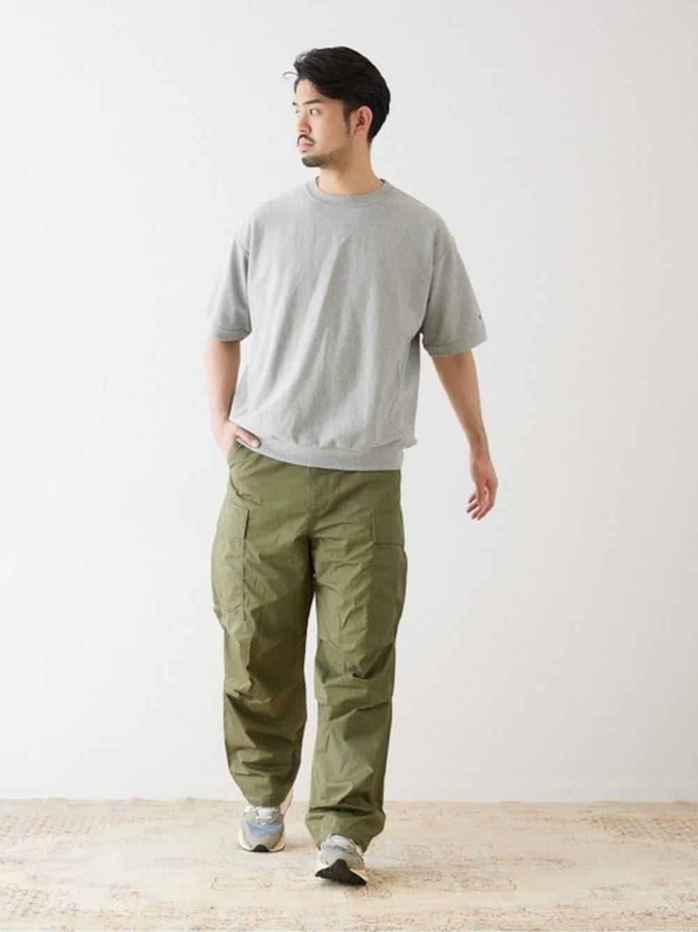 グリーン系のカーゴパンツ、グレー系のTシャツ/カットソーを着用したメンズの春コーディネートの1枚目の写真