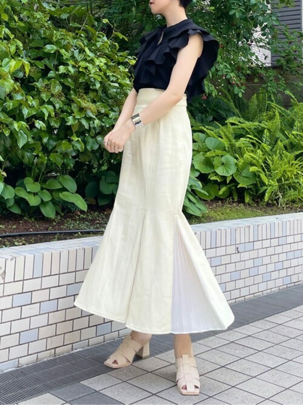 ブラック系のシャツ/ブラウス、ホワイト系のスカート、ホワイト系のサンダルを着用したレディースの夏コーディネートの1枚目の写真