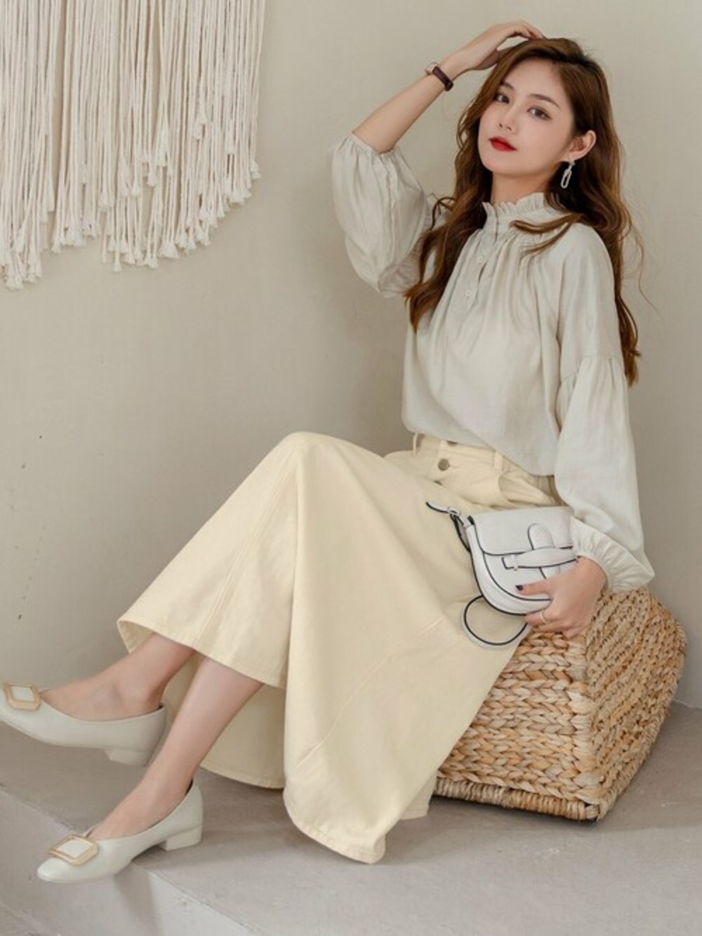 ホワイト系のデニムスカートを着用したレディースの春コーディネートの1枚目の写真