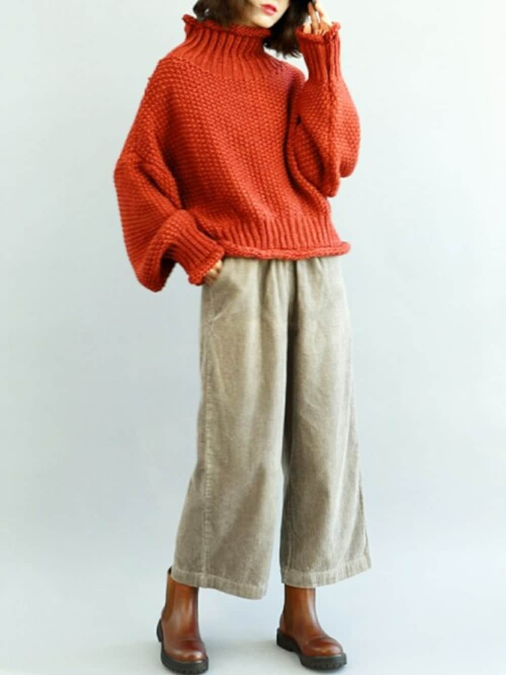 オレンジ系のニット/セーターを着用したレディースの秋コーディネートの1枚目の写真