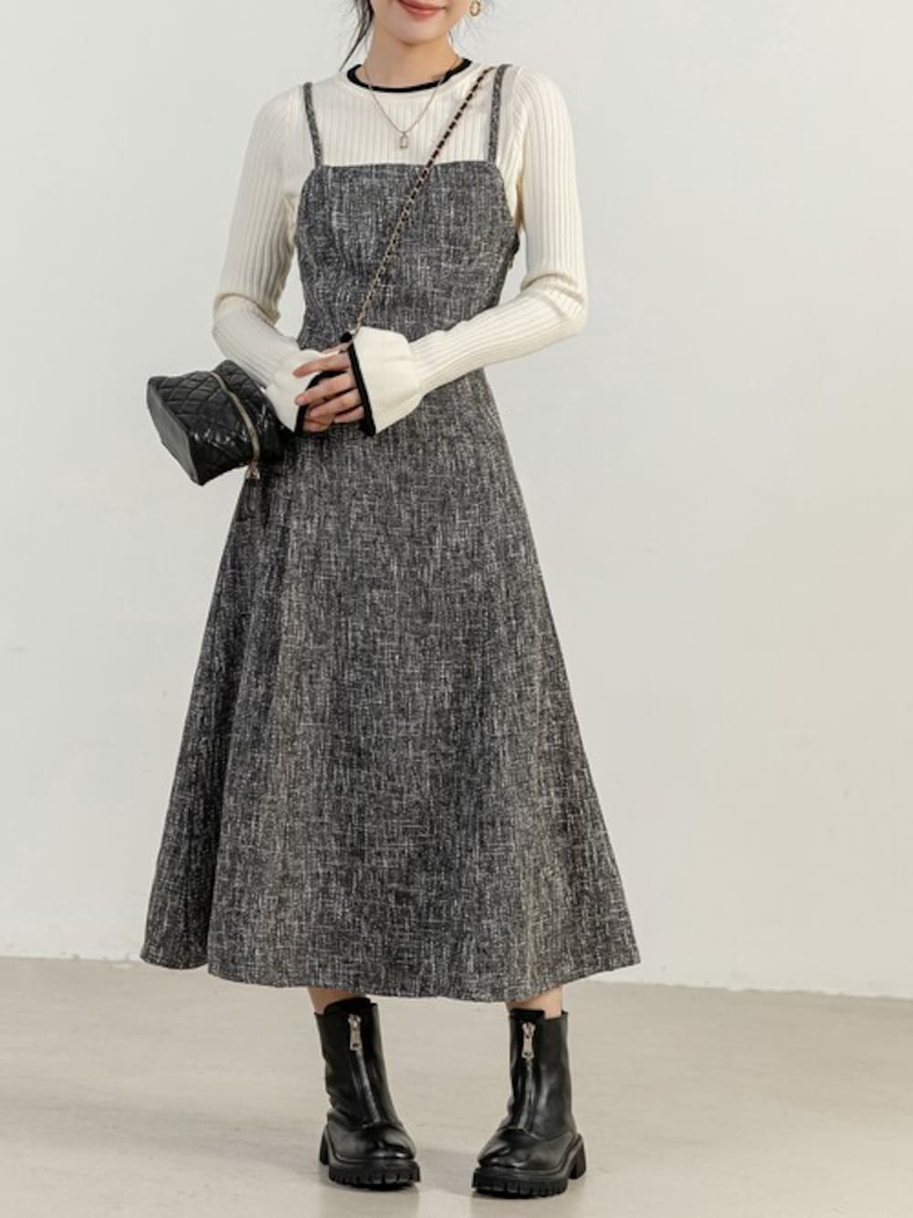 グレー系のワンピース、ホワイト系のニット/セーター、ブラック系のショルダーバッグを着用したレディースの冬コーディネートの1枚目の写真