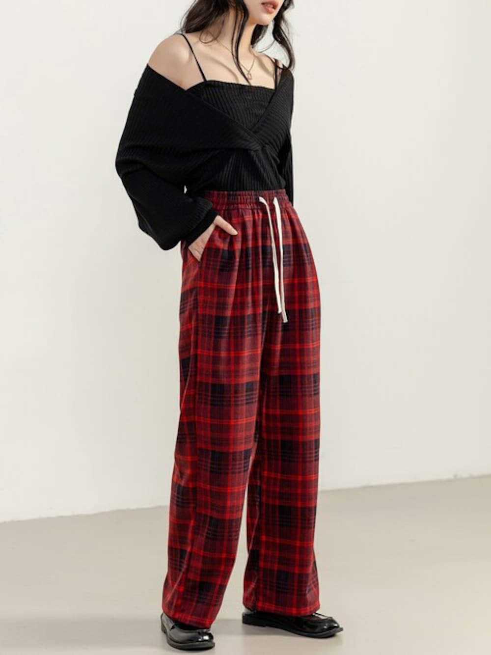 レッド系のその他パンツ、ブラック系のニット/セーターを着用したレディースの春コーディネートの1枚目の写真