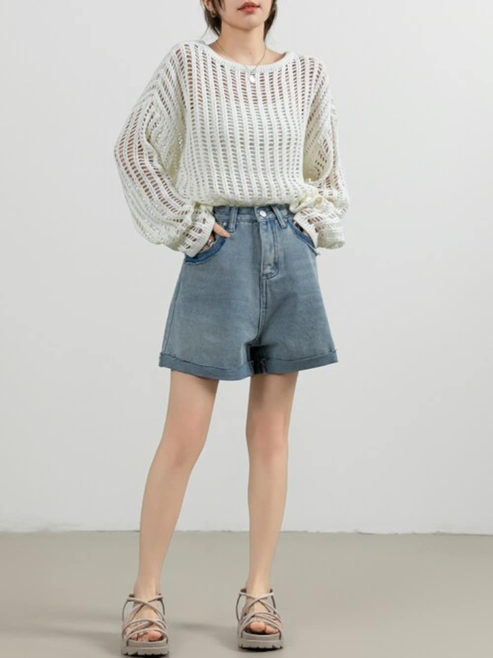 ホワイト系のニット/セーター、ブルー系のデニムパンツを着用したレディースの夏コーディネートの1枚目の写真
