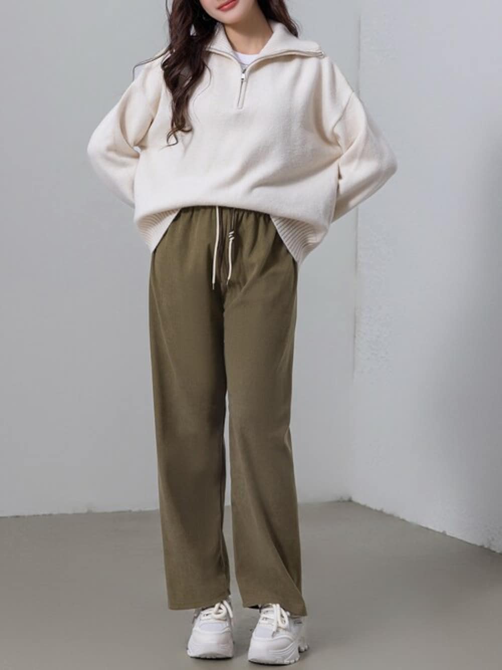 ブラウン系のその他パンツ、ホワイト系のニット/セーターを着用したレディースの冬コーディネートの1枚目の写真