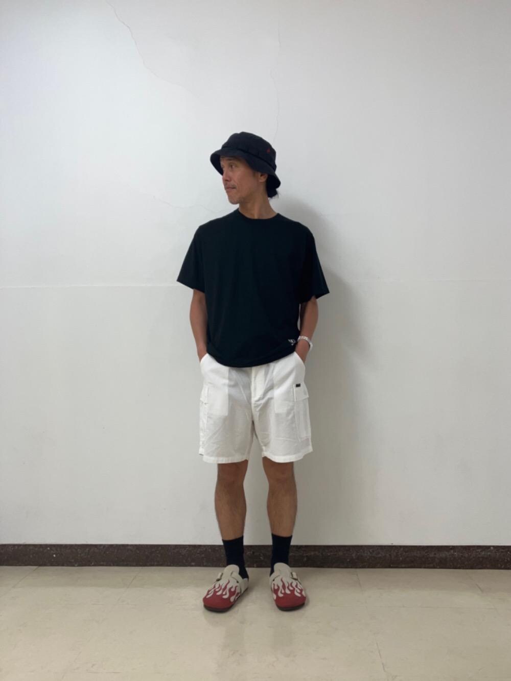 ブラック系のTシャツ/カットソー、ベージュ系のサンダル、ホワイト系のカーゴパンツを着用したメンズの夏コーディネートの1枚目の写真