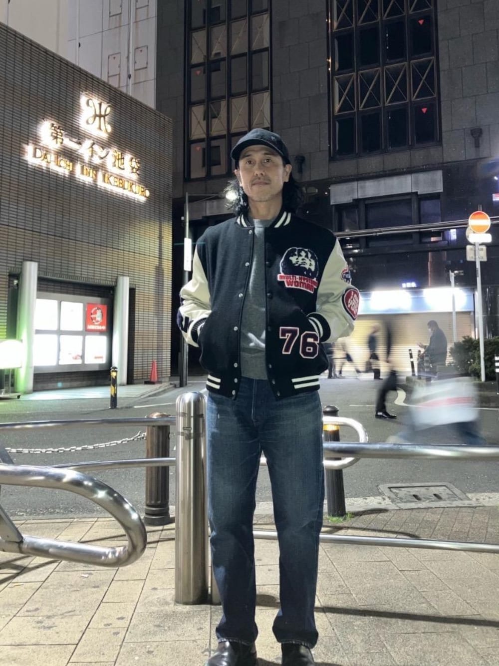 グレー系のニット/セーター、ブルー系のデニムパンツ、ブラック系のスタジャンを着用したメンズの冬コーディネートの1枚目の写真