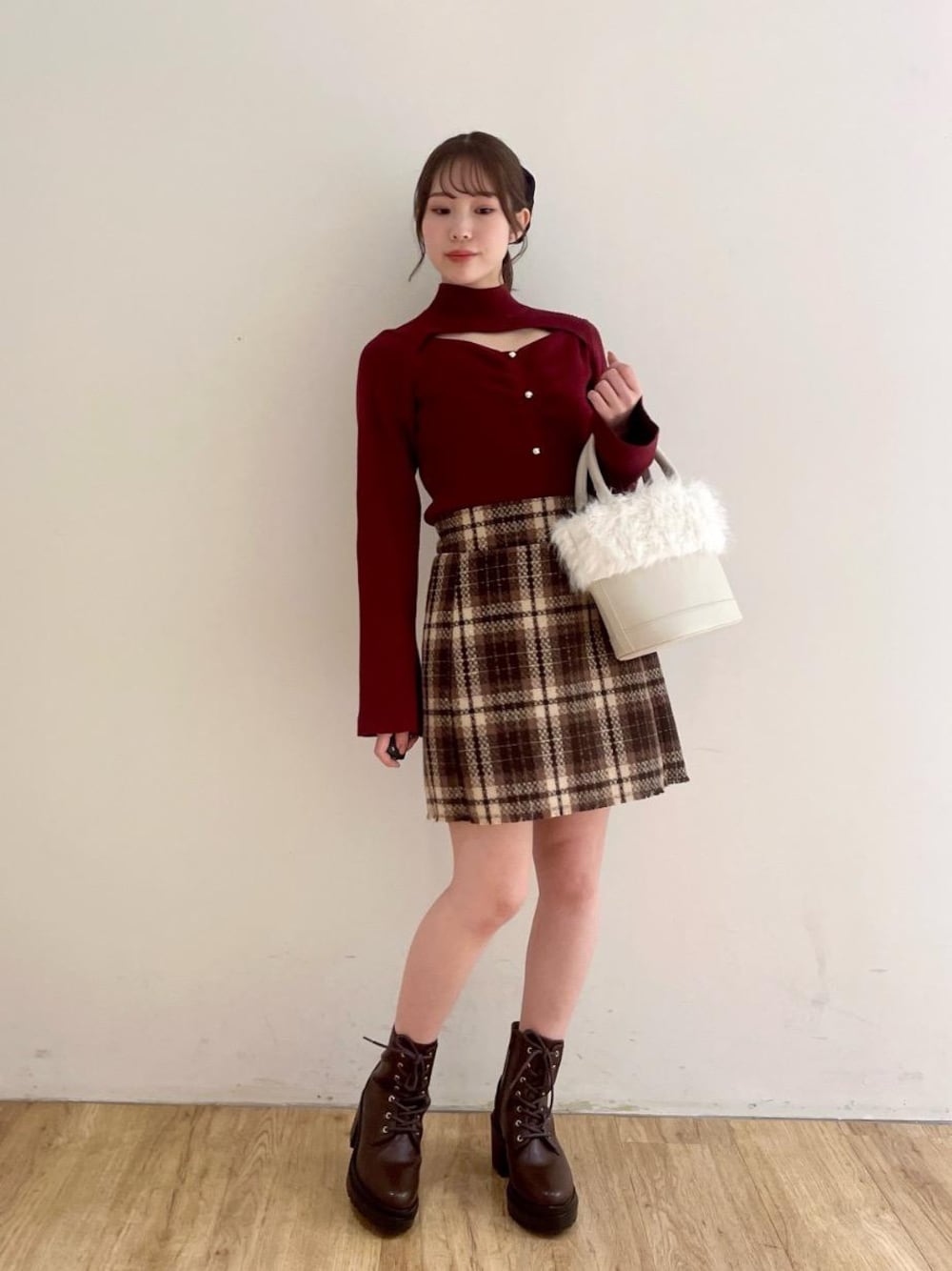 ブラウン系のブーツ、ブラウン系のスカート、ホワイト系のショルダーバッグを着用したレディースの冬コーディネートの1枚目の写真