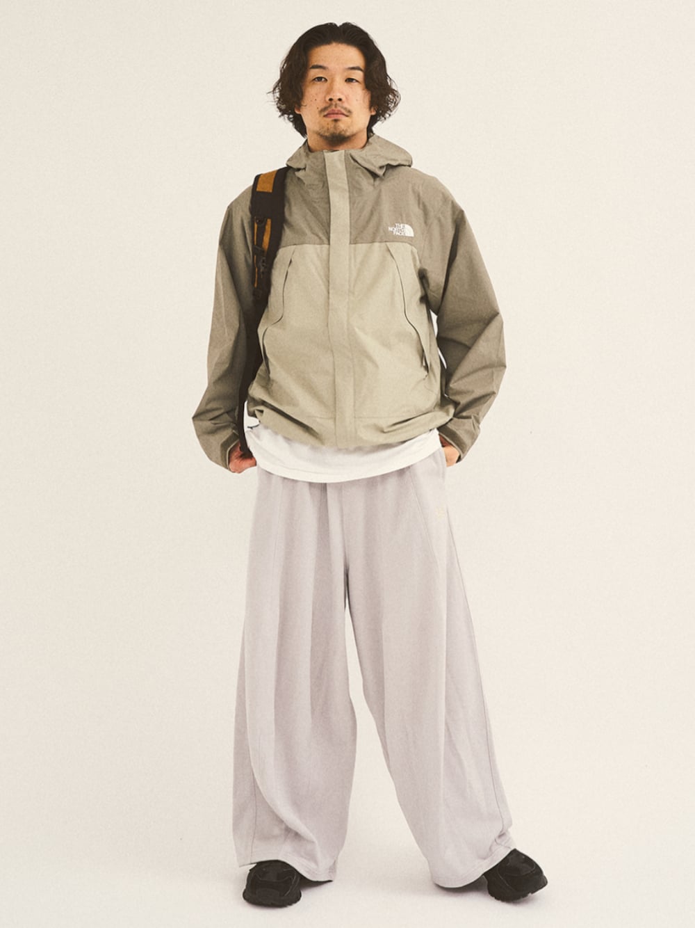 グレー系のマウンテンパーカー、イエロー系のバックパック/リュックを着用したメンズの秋コーディネートの1枚目の写真