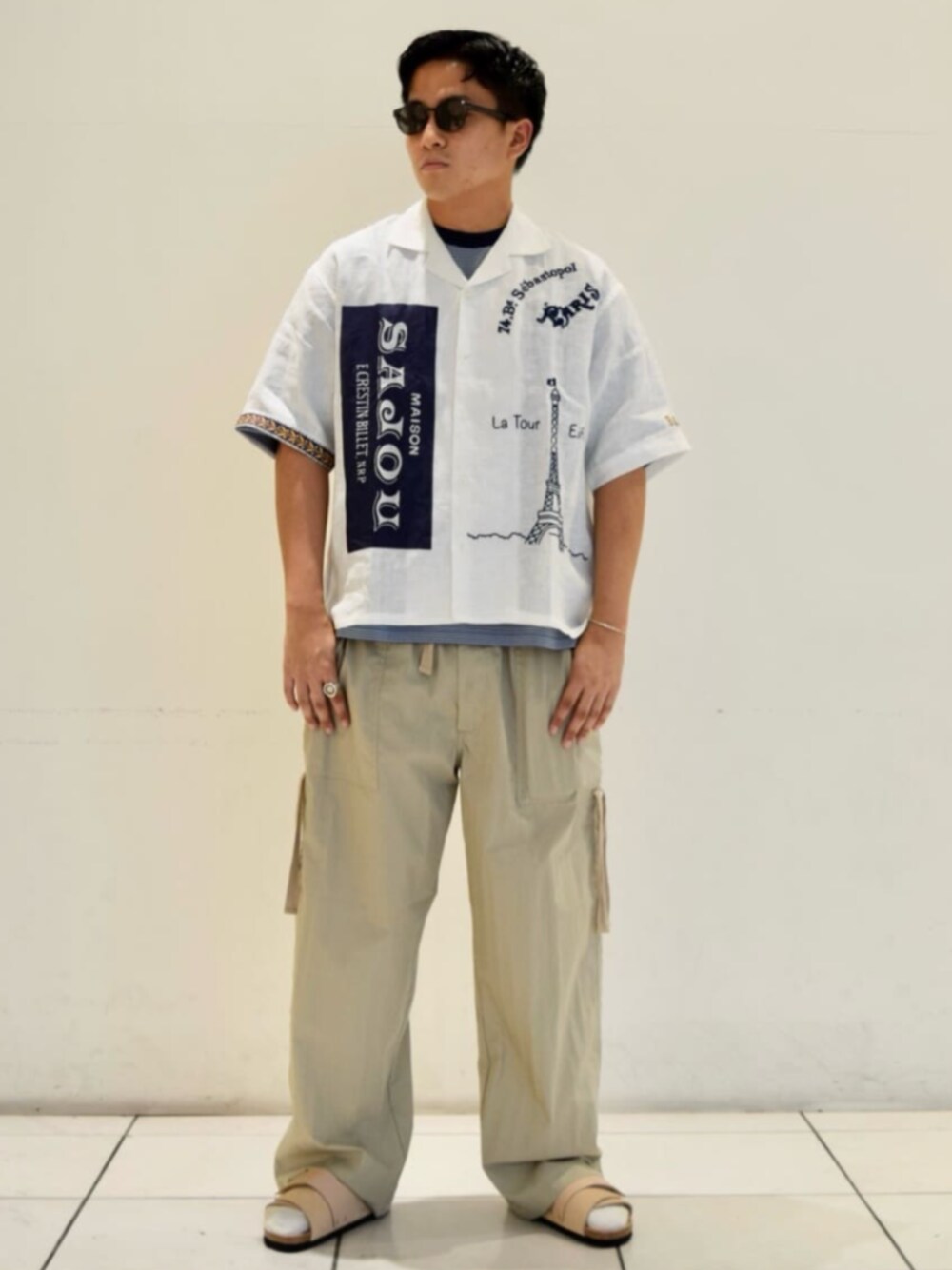 ベージュ系のサンダル、ブルー系のTシャツ/カットソー、ベージュ系のカーゴパンツを着用したメンズの夏コーディネートの1枚目の写真