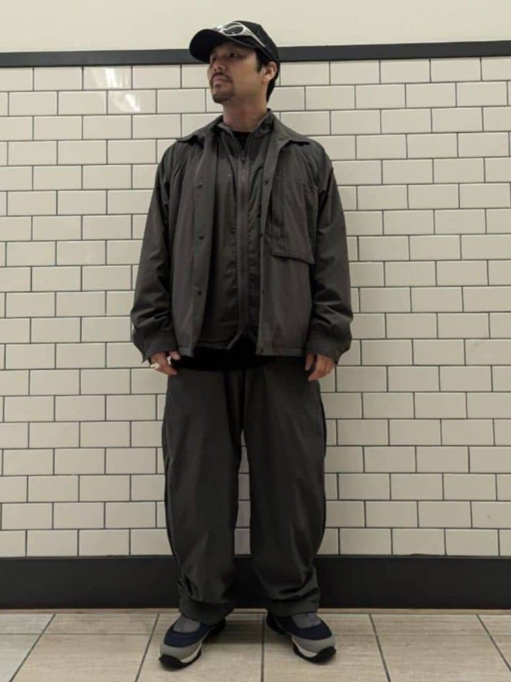 グレー系のナイロンジャケット、グレー系のカーゴパンツ、グレー系のベストを着用したメンズの秋コーディネートの1枚目の写真