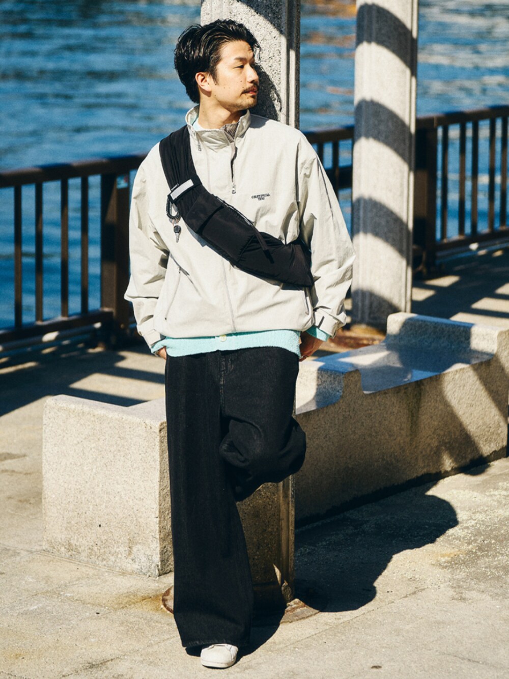 グレー系のナイロンジャケット、ブルー系のニット/セーターを着用したメンズの春コーディネートの1枚目の写真