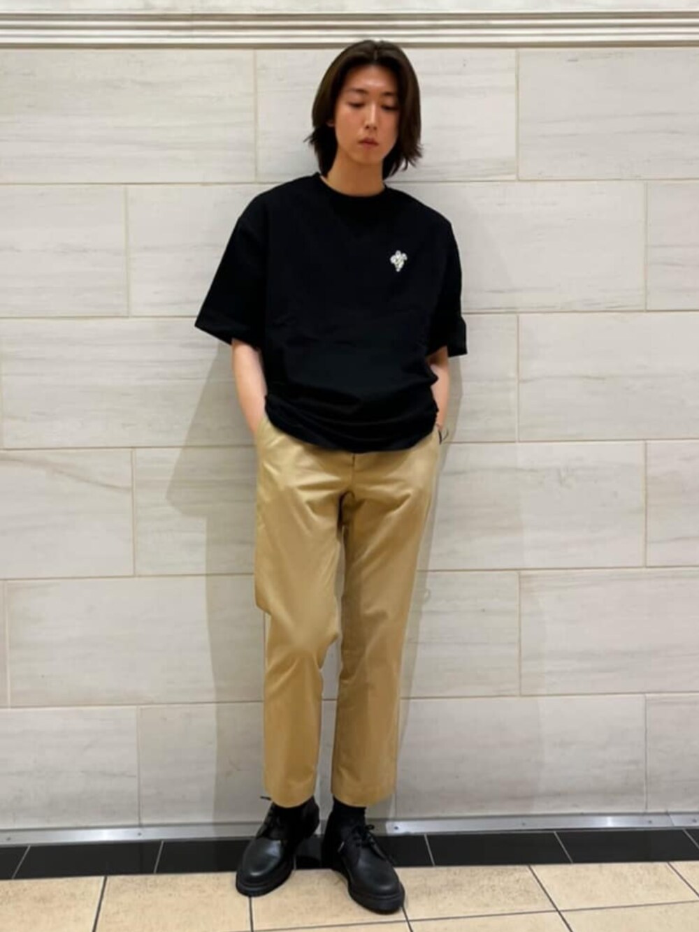 ブラック系のTシャツ/カットソー、ベージュ系のチノパンツ、ブラック系のドレスシューズを着用したメンズの春コーディネートの1枚目の写真